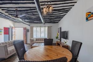 a living room with a wooden table and chairs at Auregi Villas - 2 and 3 bedroom near Diani Beach in Diani Beach
