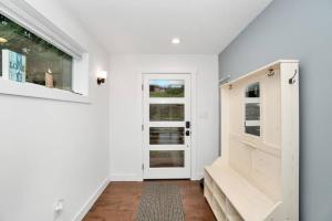 einen Flur mit weißen Wänden, einer Tür und einer Treppe in der Unterkunft Lakefront Escape with Fire Pit and Views in McKees Beach