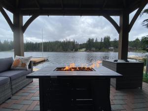 eine Feuerstelle auf einer Terrasse neben einem See in der Unterkunft Lakefront Escape with Fire Pit and Views in McKees Beach