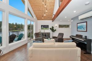 ein Wohnzimmer mit einem weißen Sofa und einem Klavier in der Unterkunft Lakefront Escape with Fire Pit and Views in McKees Beach