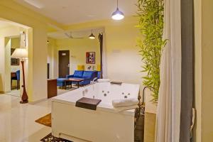 a bathroom with a bath tub in a living room at FabHotel Charvi Reemz in Anjuna