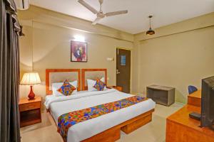 a bedroom with a large bed and a television at FabHotel Charvi Reemz in Anjuna