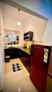 eine Küche mit einem roten Kühlschrank und einer Theke in der Unterkunft Villa 25 Eat-Sleep-Beach-Repeat in Kilpettai