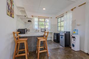 a kitchen with a counter and two stools in it at Auregi Villas - 2 and 3 bedroom near Diani Beach in Diani Beach +27 photos