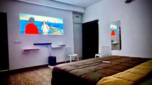 a bedroom with a bed and a large painting on the wall at Villa 25 Eat-Sleep-Beach-Repeat in Kilpettai