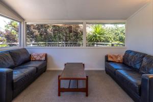 Waiheke IslandCasa Sol - Central Oneroa Retreat的客厅里有两张皮沙发和一张桌子