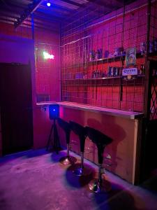 a room with a bar with stools and pink lights at Villa Lolita in Palmaseca