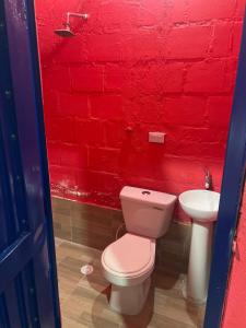 a red brick bathroom with a toilet and a sink at Villa Lolita in Palmaseca