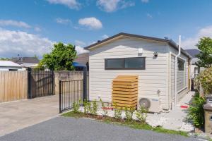 un petit cabanon blanc devant une clôture dans l'établissement Studio Unit 5 Mins Walk to CBD, à Gisborne