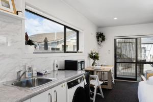 a kitchen with a sink and a table and a window at Studio Unit 5 Mins Walk to CBD in Gisborne
