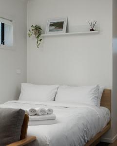 un lit blanc avec deux serviettes dessus dans l'établissement Studio Unit 5 Mins Walk to CBD, à Gisborne