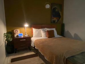 ein Schlafzimmer mit einem Bett und einem Tisch mit einer Lampe in der Unterkunft Botanique Concept House Guanajuato Centro in Guanajuato