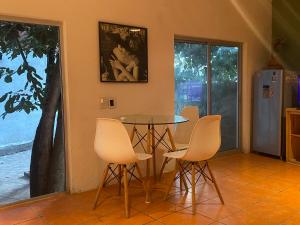 ein Esszimmer mit Glastisch und Stühlen in der Unterkunft Botanique Concept House Guanajuato Centro in Guanajuato