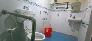 a small bathroom with a toilet and a sink at Entire 1bhk Home - Kumbha Nivas Homestay in Kumbakonam +8 photos