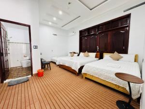 a bedroom with two beds and a mirror at Golden Hotel in Buon Ma Thuot