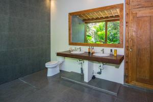La salle de bains est pourvue de 2 lavabos, d'une fenêtre et de toilettes. dans l'établissement Seseh Beach Retreat Villas, à Canggu 70 autres photos