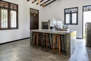 希克杜沃Villa Conch by Om的厨房配有带吧台凳的大柜台