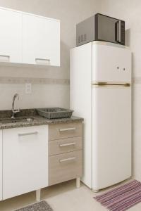 une cuisine avec un réfrigérateur blanc et un évier dans l'établissement Ludgero BLU MARE BC, à Balneário Camboriú 5 autres photos