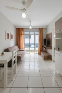 Il comprend un salon blanc avec une table et une cuisine. dans l'établissement Ludgero BLU MARE BC, à Balneário Camboriú