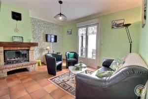 a living room with a couch and a fireplace at Le jardin in Plestin-les-Grèves