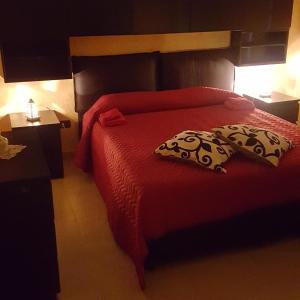 a bedroom with a red bed with two pillows on it at La Casa di Ninna Affittacamere in Ariano Irpino