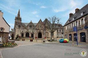 an old stone building with a church and a street at Le jardin in Plestin-les-Grèves