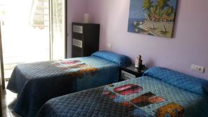 - une chambre avec 2 lits et une photo sur le mur dans l'établissement Apartamento Puerto Real, à Torremolinos