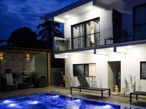 uma casa com uma piscina em frente à mesma à noite em Home Aguas da barra Ilhabela em Ilhabela