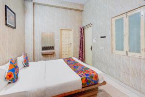 a bedroom with a bed and a window at FabHotel Citi Residenci in Varanasi