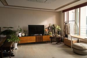 Una sala de estar con un televisor de pantalla plana sobre un mueble de madera. en Josh's Homestay, 