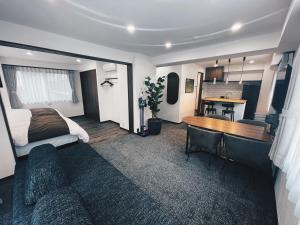 东京Plan A Tennozu Isle的一间卧室，配有一张床、一张书桌和一张桌子