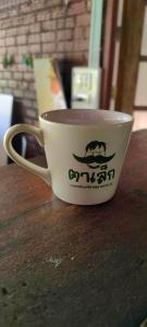 eine Kaffeetasse auf einem Tisch in der Unterkunft ตาเล็ก ฟาร์มสเตย์ 