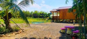 einen Hof mit einem Haus, einem Baum und einem Gebäude in der Unterkunft ตาเล็ก ฟาร์มสเตย์ 