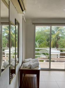 una habitación con dos espejos y un banco con toallas en Departamento AAK, en Mérida