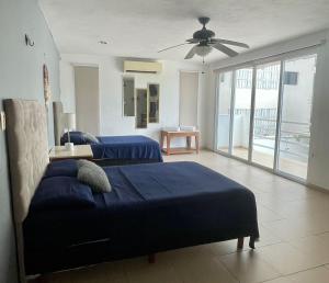 Un dormitorio con dos camas y un ventilador de techo. en Departamento AAK, en Mérida 10 fotos más