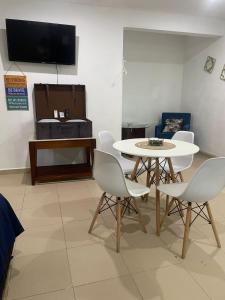 Un comedor con mesa y sillas y un televisor. en Departamento AAK, en Mérida