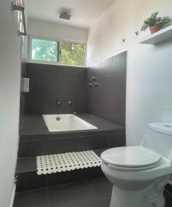 Un baño con bañera, inodoro y lavabo. en Departamento AAK, en Mérida