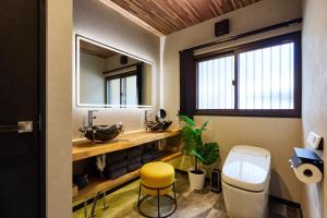 baño con lavabo y taburete amarillo en 富士山を見ながらサウナBBQ The No10 MtFuji Forest House, en Yamanakako 25 fotos más