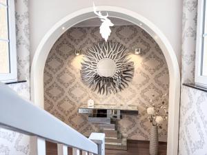 un couloir avec un escalier et un miroir mural dans l'établissement WILD&COZY Ferienhaus mit luxuriöser Küche & Garage, à Blankenburg 23 autres photos