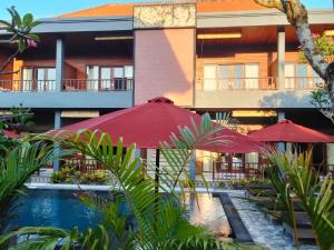 蓝梦岛C'man Guest House的配有红色遮阳伞和游泳池的酒店