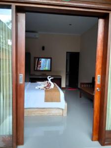 蓝梦岛C'man Guest House的一间卧室，里面有一张床和一台电视