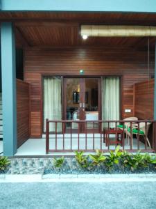 蓝梦岛C'man Guest House的带阳台的房子，配有桌子和椅子