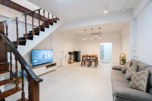 a living room with a couch and a television at Peaceful 2BR Home Walk to Halal Street Food in Hat Yai