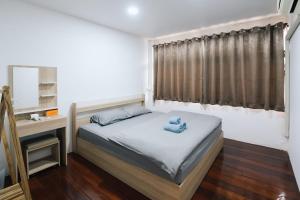 a bedroom with a bed and a desk with a mirror at Peaceful 2BR Home Walk to Halal Street Food in Hat Yai