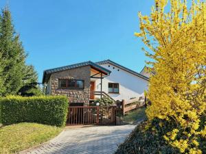 une maison avec une porte en bois et une clôture dans l'établissement 1970S Architects House In The Countryside, à Rochlitz