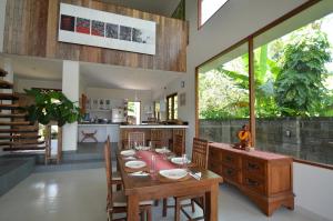 un comedor con una mesa con platos. en Villa Santai Karangasem, en Tirtagangga