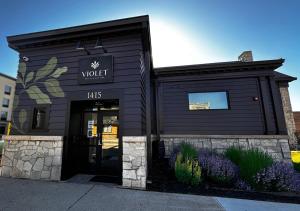 un bâtiment noir avec une pancarte sur la porte dans l'établissement Violet Inn, Lounge & Spa, à Two Rivers