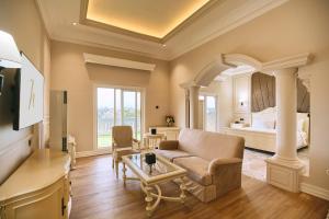 ein Wohnzimmer mit einer Couch und einem Bett in der Unterkunft Horison Resort Tulip Puncak in Cipanas