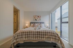 a bedroom with a bed and a large window at Gloucester Escape Modern 2BR with Outdoor Space in Linwood