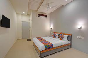 Un dormitorio con una cama y un televisor de pantalla plana. en FabHotel Stay In, en Vadodara